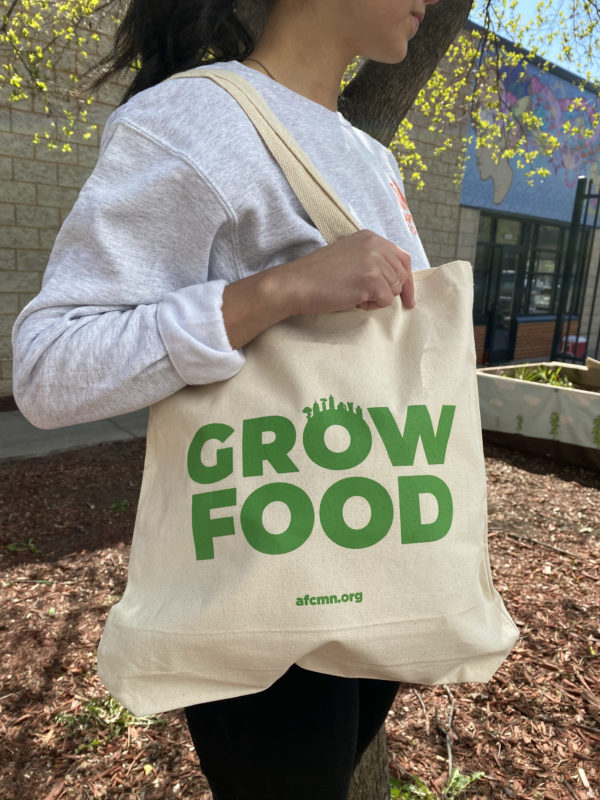 woman holding canvas handbag with grow food logo