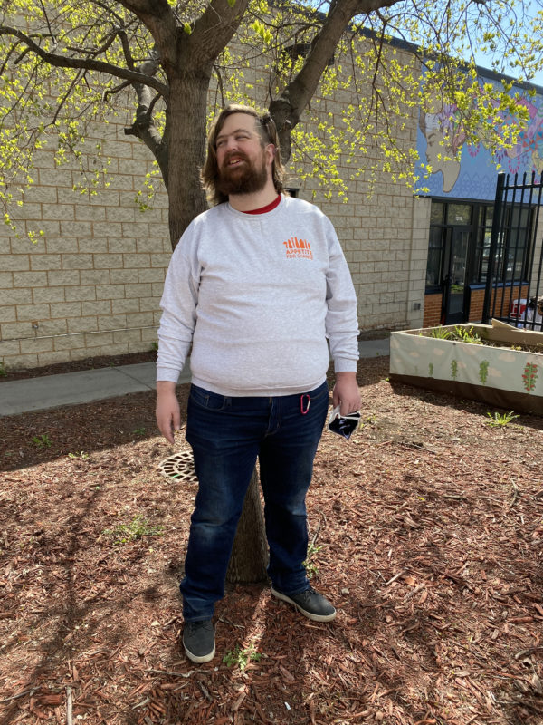 man wearing sweatshirt with orange Appetite For Change logo
